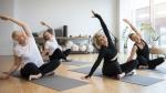Frauen auf Yogamatte, die eine Seitbeuge praktizieren © Freepik