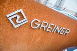 Logo der Firma Greiner auf braunem Hintergrund © GREINER GmbH