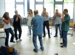 Mehrere Menschen stehen im Kreis und spielen Mundharmonika. © Didi Neumann