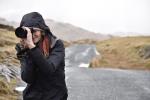 Frau mit Fotokamera vor Landschaft. Bild © pixabay