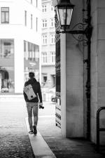 Mann mit Rucksack und Kamera von hinten in einem Torbogen. Bild © Pixabay