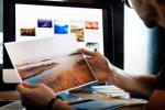 Ein Mann vor einem Computerbildschirm. Er hält Bilder in der Hand. Bild © Pixabay