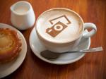 Eine Tasse Cappuccino mit dem Symbol einer Kamera im Milchschaum. Bild © Pixabay