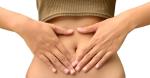 Frau mit bauchfreiem Top formt ein Herz mit Händen auf ihren Bauch © Pixabay