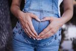 Mama in Latzhosen formt ein Herz mit den Händen auf ihren Bauch © pixabay