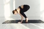 weibliche Person führt Pilates-Übung auf einer schwarzen Matte aus © pexels