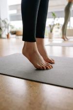auf Zehenspitzen stehende Person auf Matte © pexels