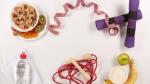 Springseil, Wasserflasche, Banane, Apfel, Joghurt und Müslischale nebne Maßband auf weißem Grund © canva.com