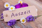 Kerze und Blüten mit Aufschrift Auszeit auf einem Zettel © Floydine - Fotolia