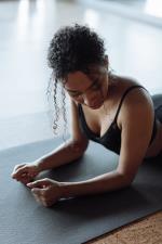 weibliche Person liegt auf dem Bauch auf einer schwarzen Matte © pexels
