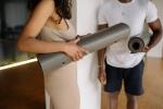zwei Personen mit Pilates-Matten unter dem Arm die sich unterhalten c) Pexels